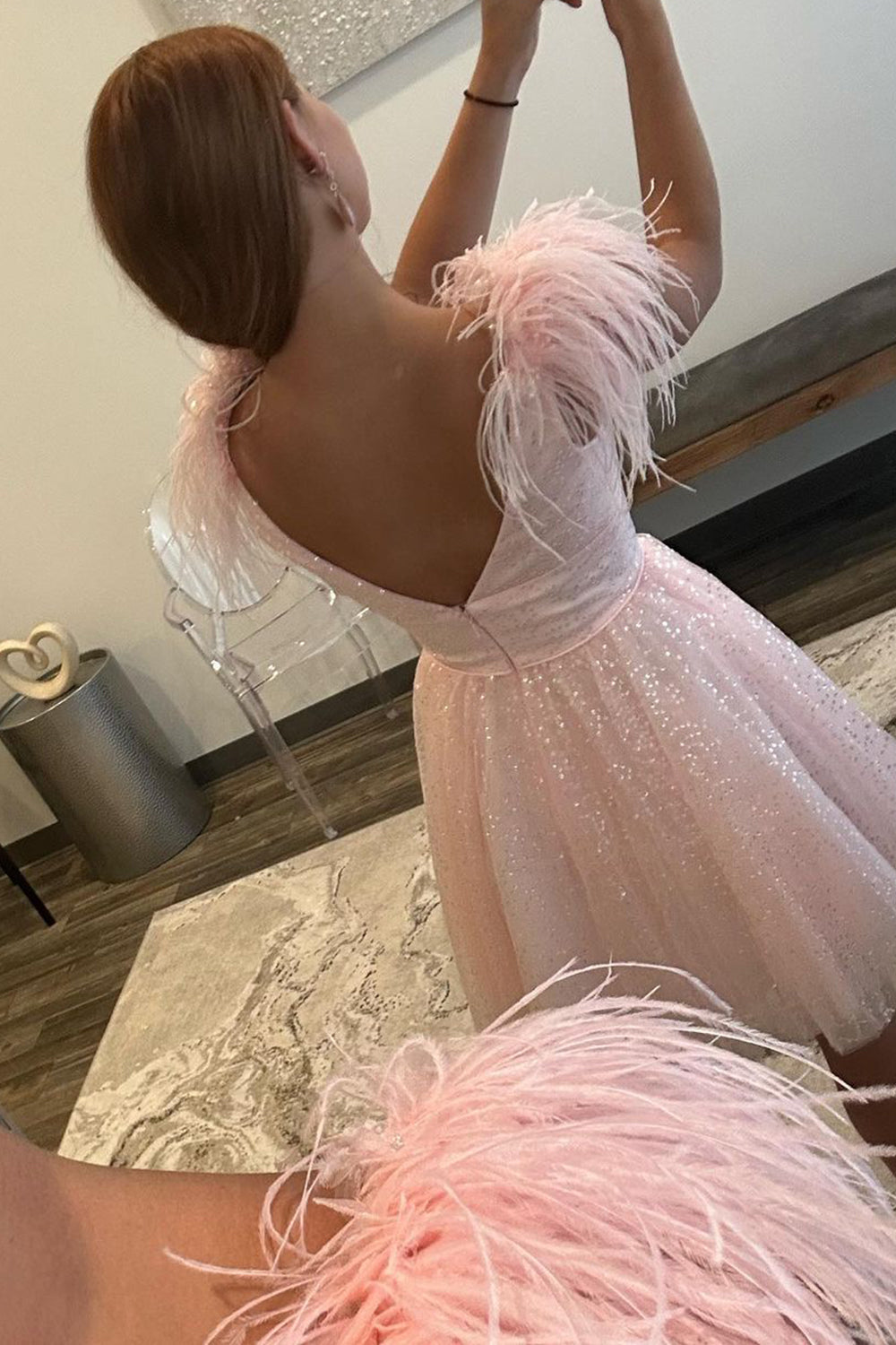 Vestido corto rosa claro de fiesta con escote en V profundo y corte en A, con plumas.