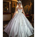 Robe de mariée rétro en satin ornée d'appliqués et de perles, décolleté en cœur, manches illusion, laçage, style princesse, confection sur mesure.