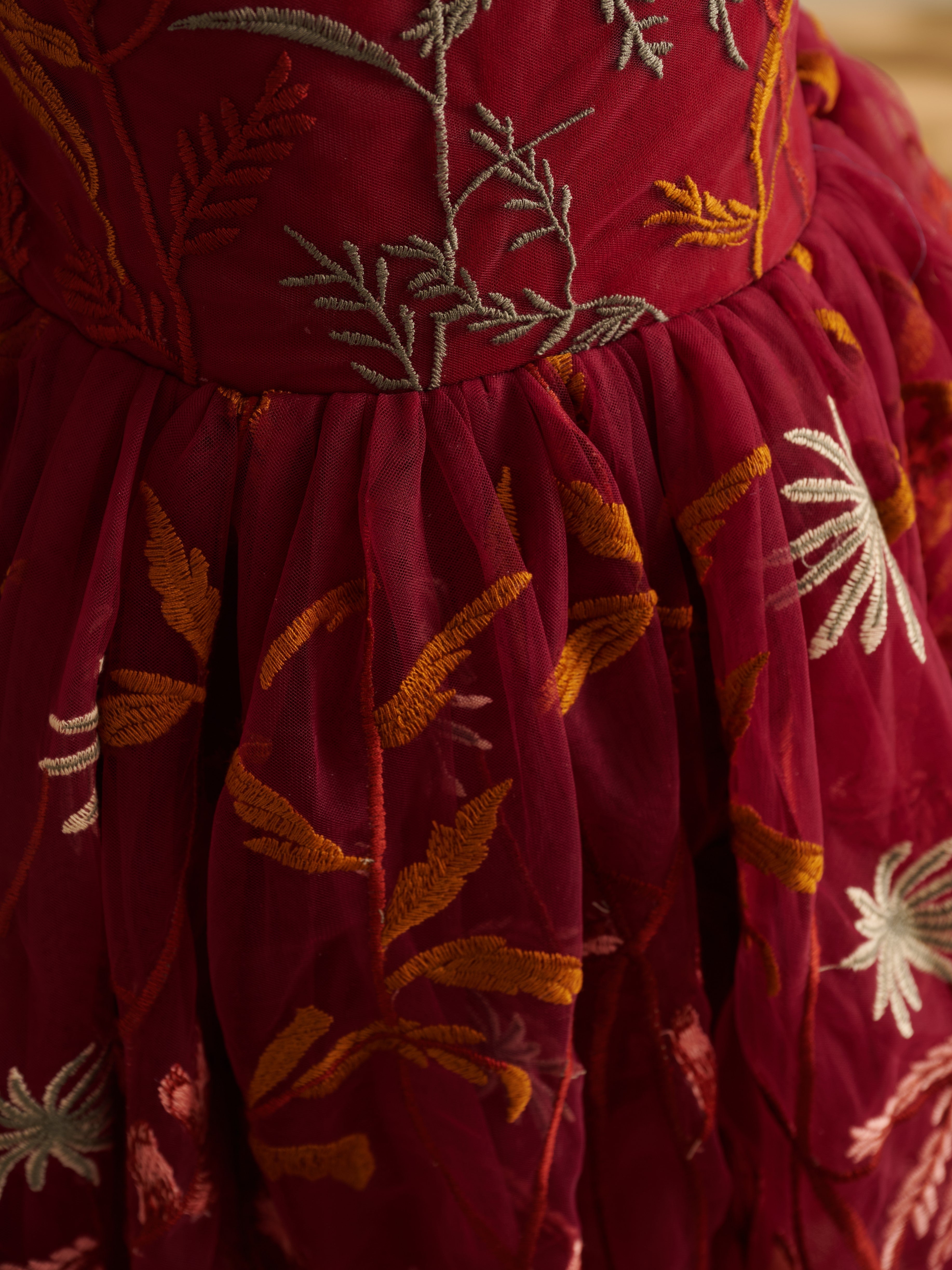 Vestido de niña pequeña hasta la rodilla, de encaje y tul color naranja quemado con bordados. 