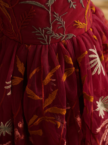 Vestido de niña pequeña hasta la rodilla, de encaje y tul color naranja quemado con bordados. 