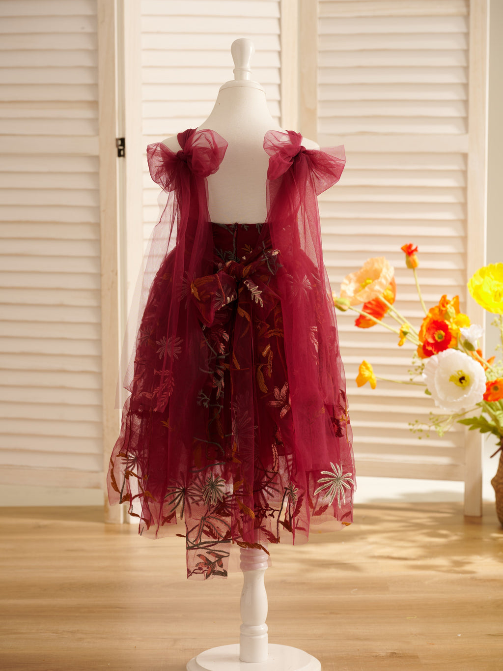 Vestido de niña pequeña hasta la rodilla, de encaje y tul color naranja quemado con bordados. 