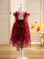 Vestido de niña pequeña hasta la rodilla, de encaje y tul color naranja quemado con bordados. 