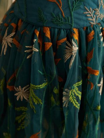 Vestido de niña pequeña hasta la rodilla, de encaje y tul color naranja quemado con bordados. 