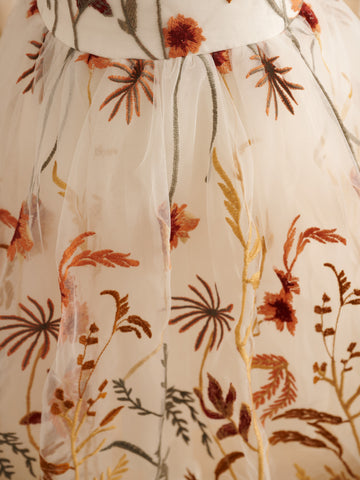 Vestido de niña pequeña hasta la rodilla, de encaje y tul color naranja quemado con bordados. 