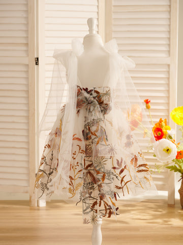 Vestido de niña pequeña hasta la rodilla, de encaje y tul color naranja quemado con bordados. 