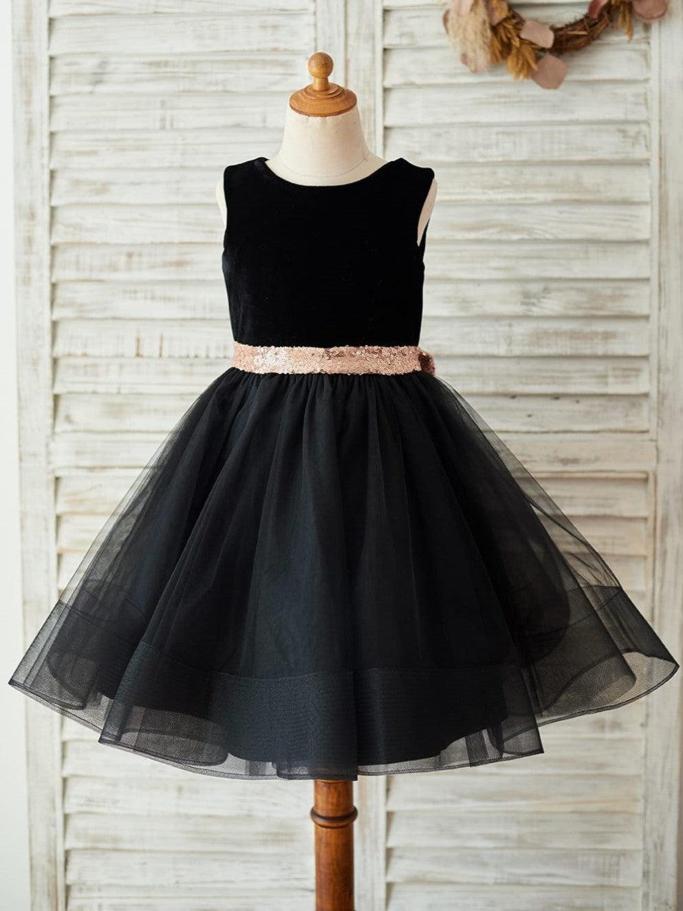Vestido negro de terciopelo con lazo de lentejuelas en forma de corazón en la espalda y largo hasta la rodilla 