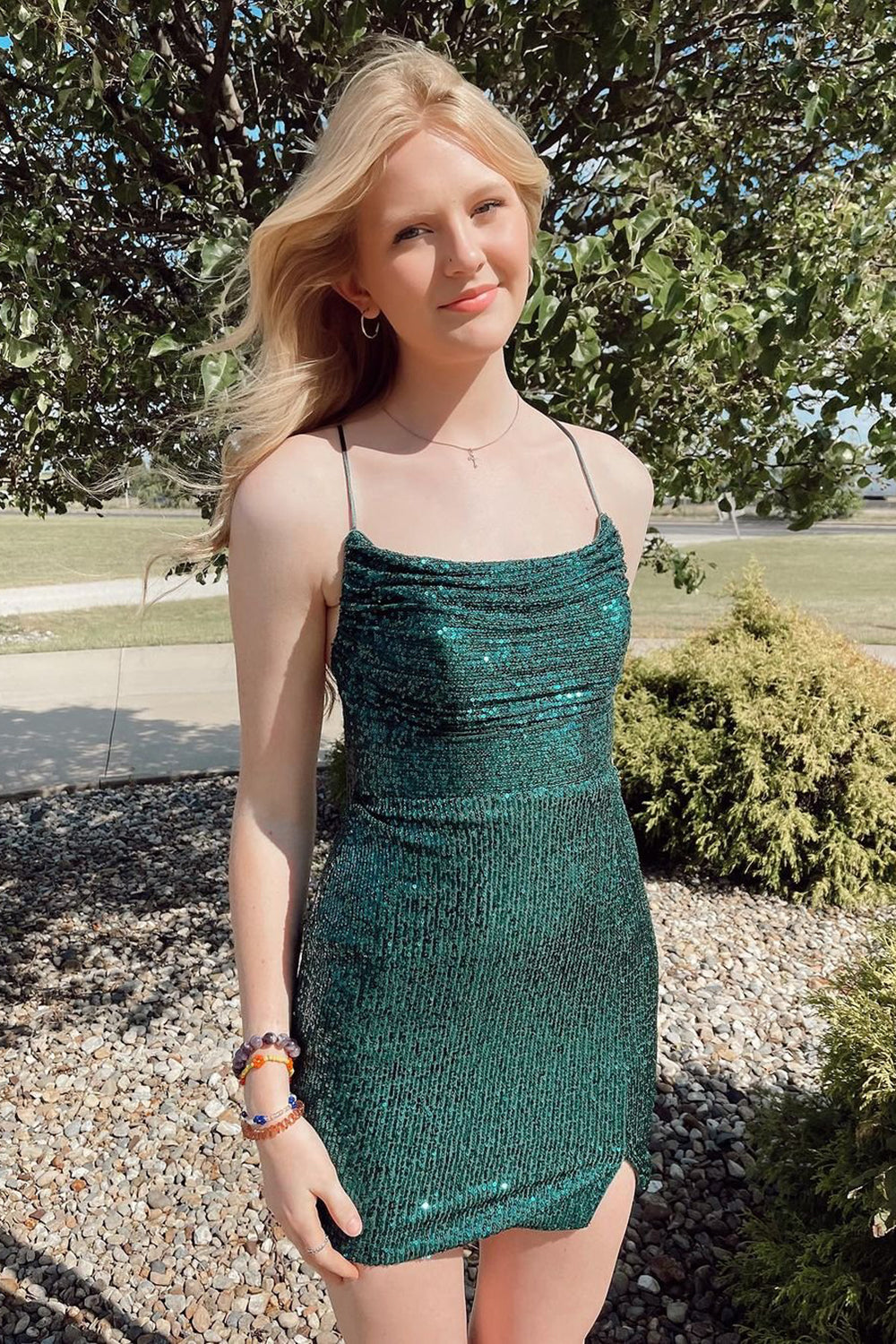Vestido corto de fiesta verde con lentejuelas brillantes, tirantes finos y espalda cruzada.