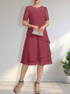 Vestido de novia de corte línea A con escote ilusión, largo hasta la rodilla, de encaje y gasa con lentejuelas.