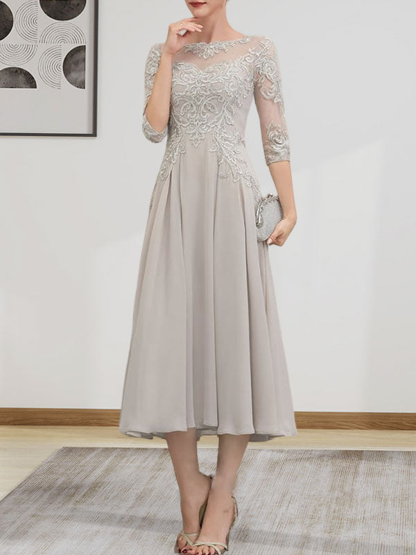 Robe de mariée trapèze en mousseline de soie et dentelle, longueur thé, ornée de perles et de sequins, avec décolleté en A et effet illusion.