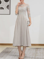 Robe de mariée trapèze en mousseline de soie et dentelle, longueur thé, ornée de perles et de sequins, avec décolleté en A et effet illusion.