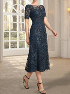 Vestido de novia de encaje con lentejuelas, corte en A, escote redondo ilusión y largo hasta la rodilla.