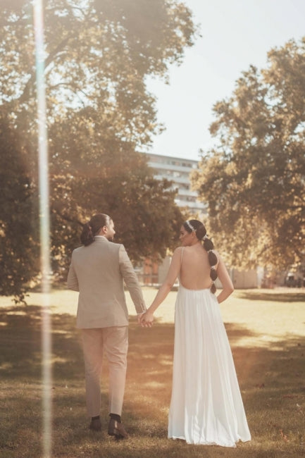 Robe de mariée longue blanche asymétrique sans manches, ornée de perles et fendue, qui me fait craquer.