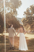 Robe de mariée longue blanche asymétrique sans manches, ornée de perles et fendue, qui me fait craquer.