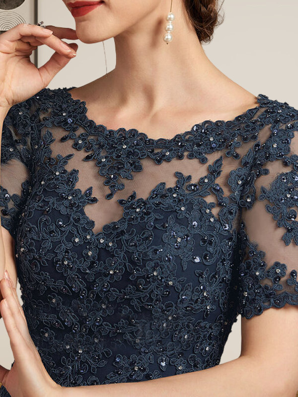 Robe de mariée longue en mousseline de soie et dentelle, coupe trapèze, décolleté illusion, ornée de sequins et de perles.