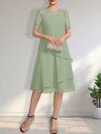 Vestido de novia de corte línea A con escote ilusión, largo hasta la rodilla, de encaje y gasa con lentejuelas.