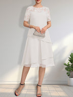 Vestido de novia de corte línea A con escote ilusión, largo hasta la rodilla, de encaje y gasa con lentejuelas.