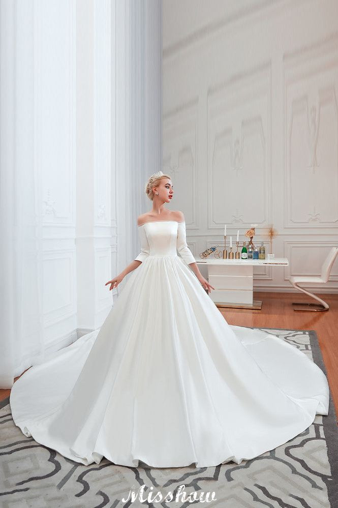 Vestido de novia blanco de corte princesa, manga tres cuartos, hombros descubiertos y línea A.