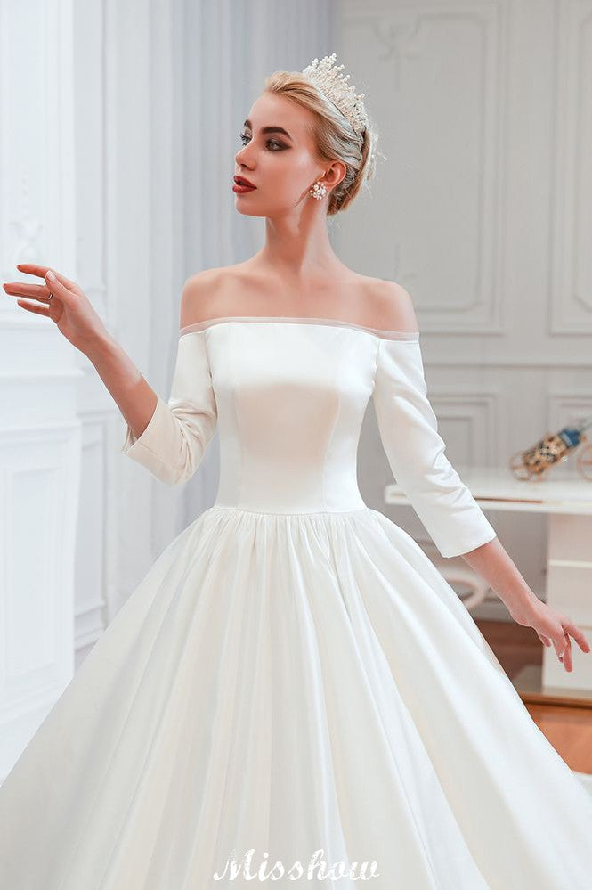 Vestido de novia blanco de corte princesa, manga tres cuartos, hombros descubiertos y línea A.