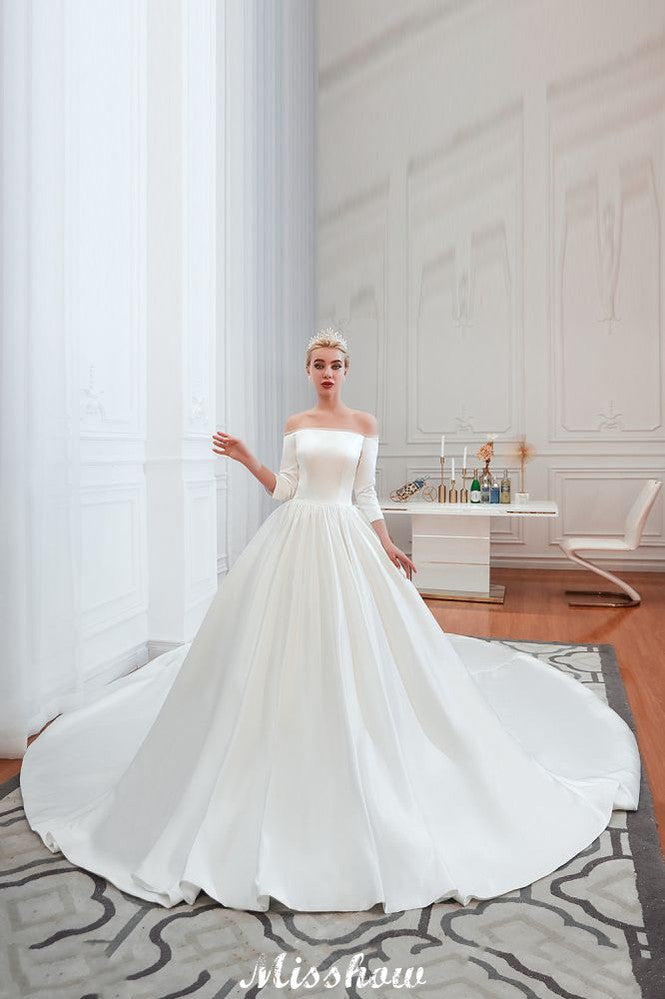 Vestido de novia blanco de corte princesa, manga tres cuartos, hombros descubiertos y línea A.