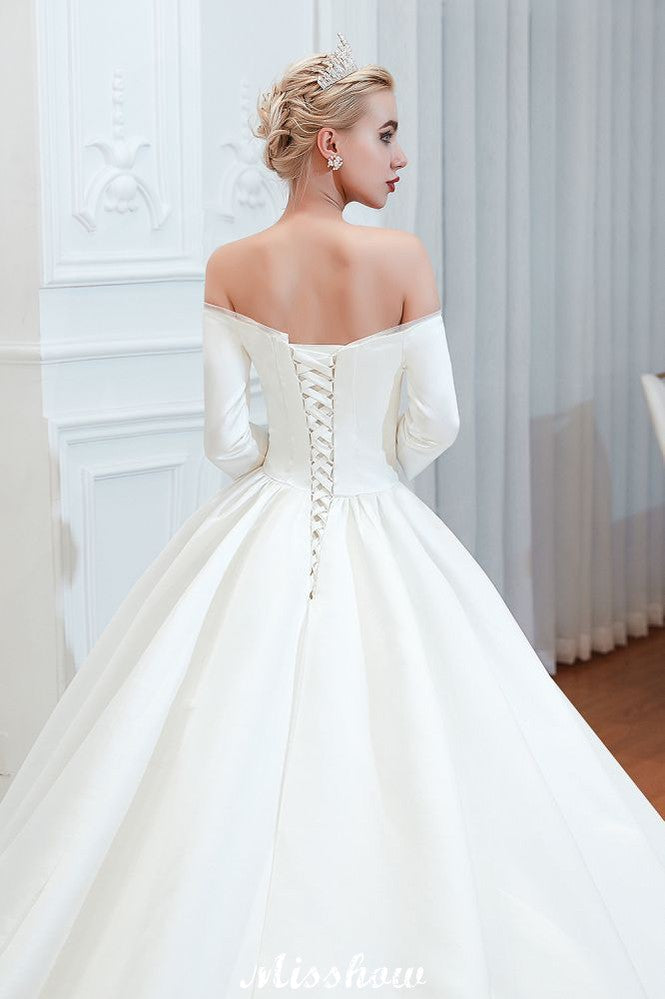Vestido de novia blanco de corte princesa, manga tres cuartos, hombros descubiertos y línea A.