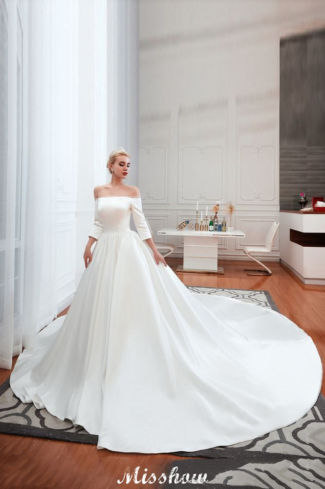 Vestido de novia blanco de corte princesa, manga tres cuartos, hombros descubiertos y línea A.