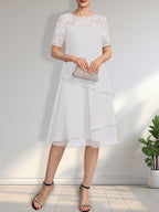 Vestido de novia de corte línea A con escote ilusión, largo hasta la rodilla, de encaje y gasa con lentejuelas.