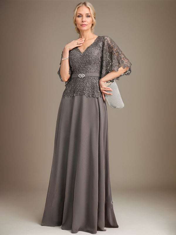 Vestido de novia de corte A, escote en V, largo hasta el suelo, de gasa y encaje, con broche de cristal y pedrería. 