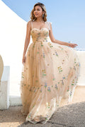 Vestido de fiesta color champán con tirantes finos, corte en A y apliques