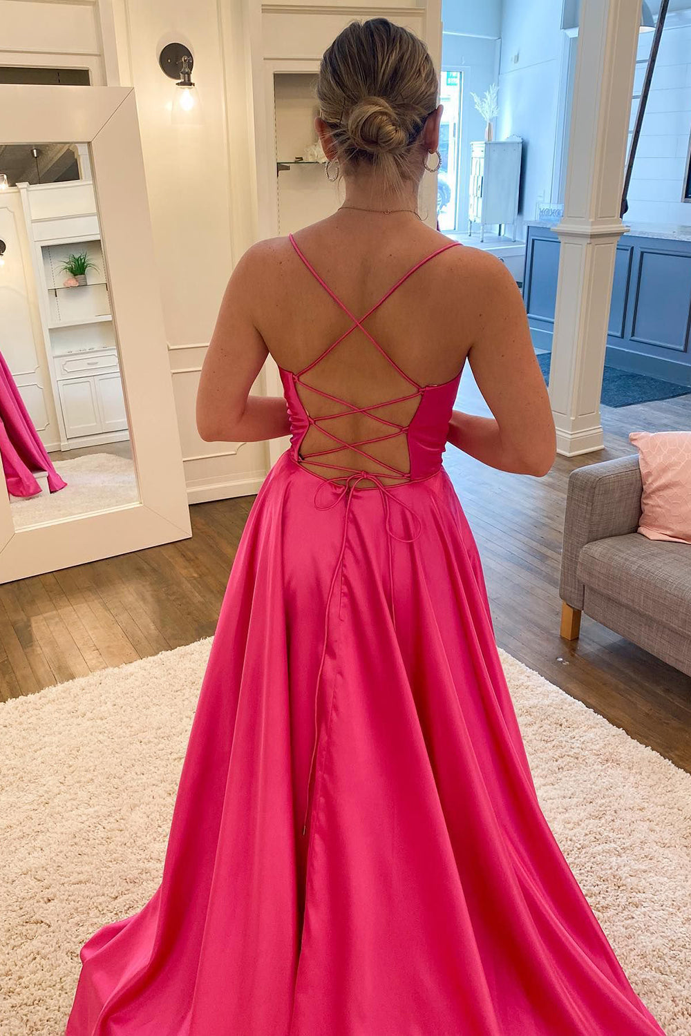Vestido largo de fiesta rosa fucsia con tirantes finos, corte en A y abertura frontal.