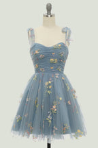 Robe de bal de promo champagne à fines bretelles et coupe trapèze, ornée de broderies.