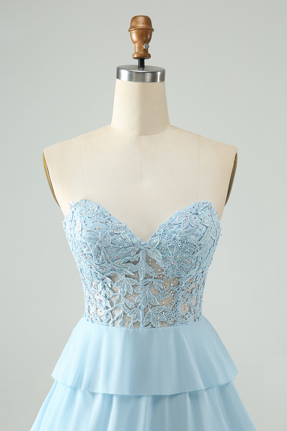 Vestido corto de fiesta azul claro con escote corazón, corte en A y volantes, con apliques.