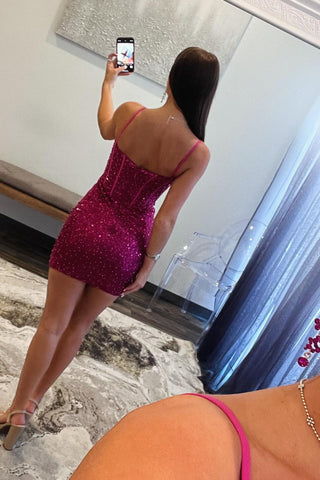 Vestido corto ajustado tipo corsé con tirantes finos, lentejuelas y color fucsia brillante.