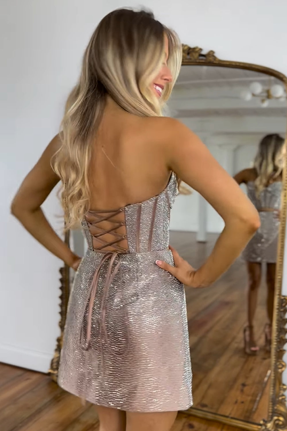 Robe de bal courte à corset court or rose pailleté et décolleté en cœur. Corset orné de perles.