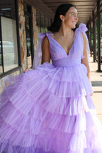 Robe de bal longue princesse en tulle lilas à bretelles ajustables et fente, ornée de volants.