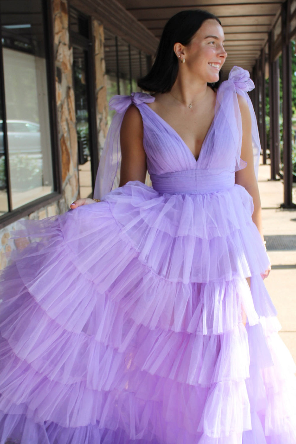Robe de bal longue princesse en tulle lilas à bretelles ajustables et fente, ornée de volants.