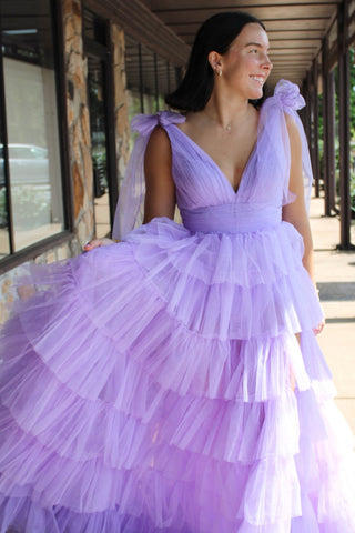 Robe de bal longue princesse en tulle lilas à bretelles ajustables et fente, ornée de volants.