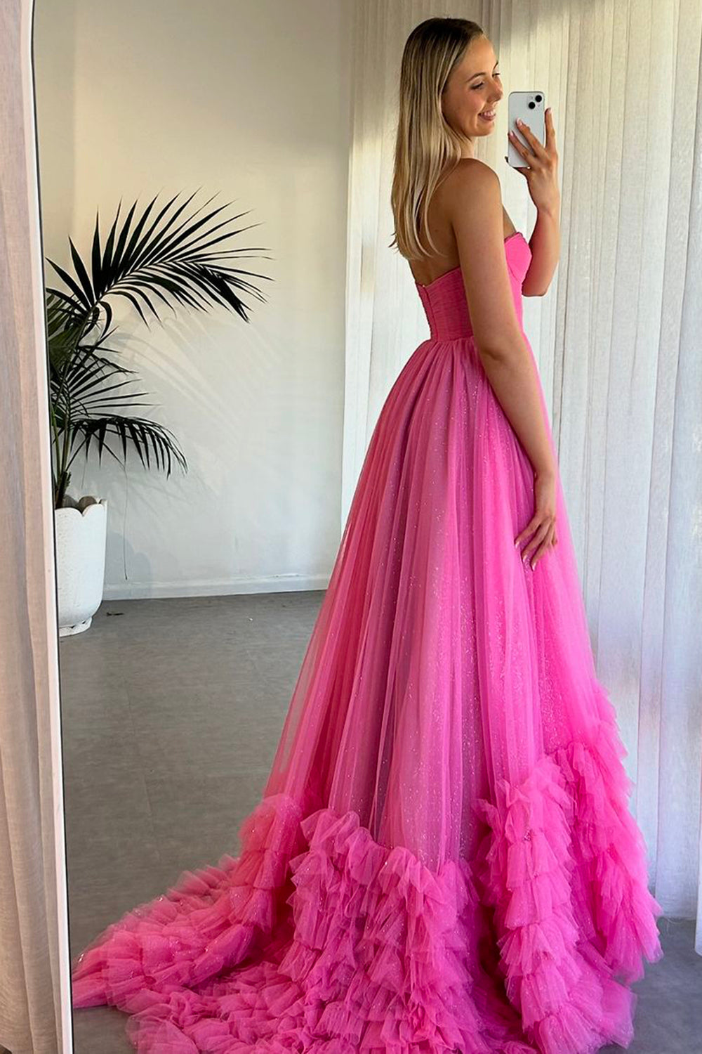 Robe de bal longue en tulle à décolleté cœur, coupe trapèze, corset à volants et fente.