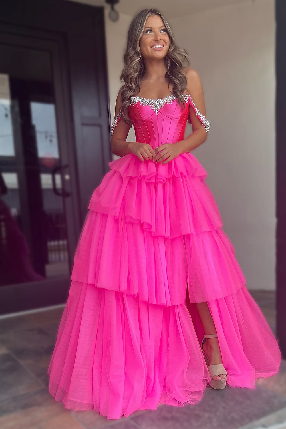 Robe de bal longue en tulle à épaules dénudées, coupe trapèze, bustier à volants et fente.