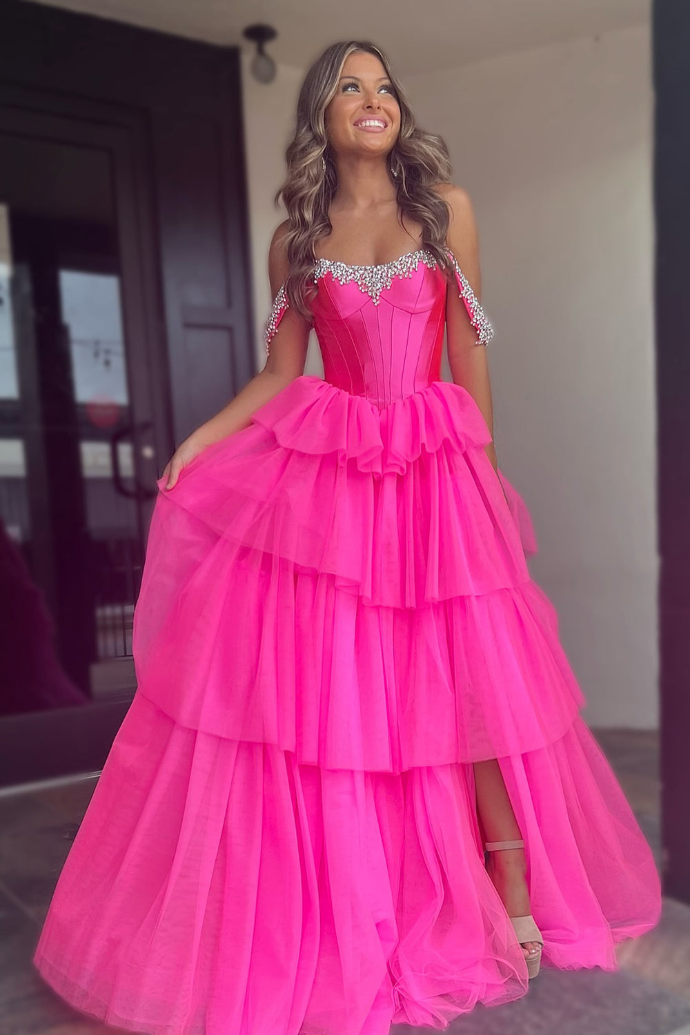 Robe de bal longue en tulle à épaules dénudées, coupe trapèze, bustier à volants et fente.