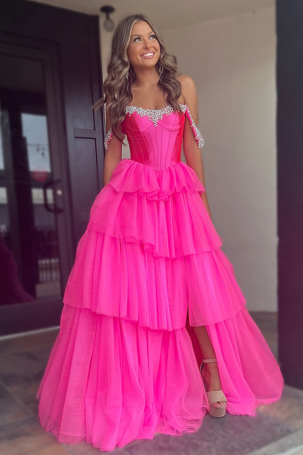 Robe de bal longue en tulle à épaules dénudées, coupe trapèze, bustier à volants et fente.