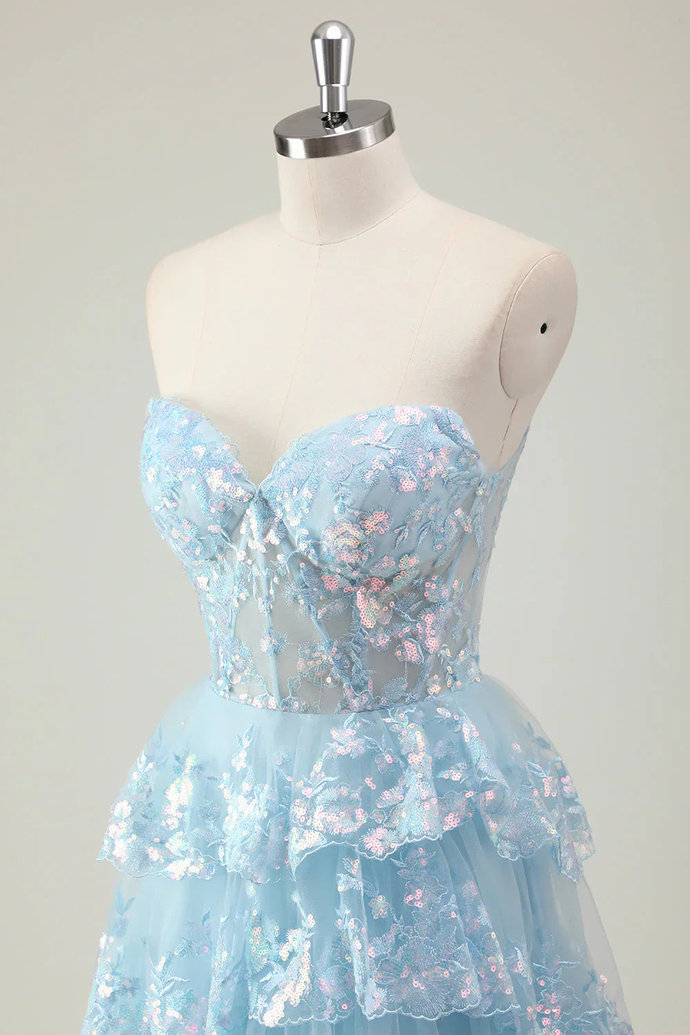 Robe de bal longue à sequins scintillants, coupe trapèze, bustier à volants et fente.