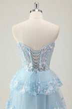 Robe de bal longue à sequins scintillants, coupe trapèze, bustier à volants et fente.
