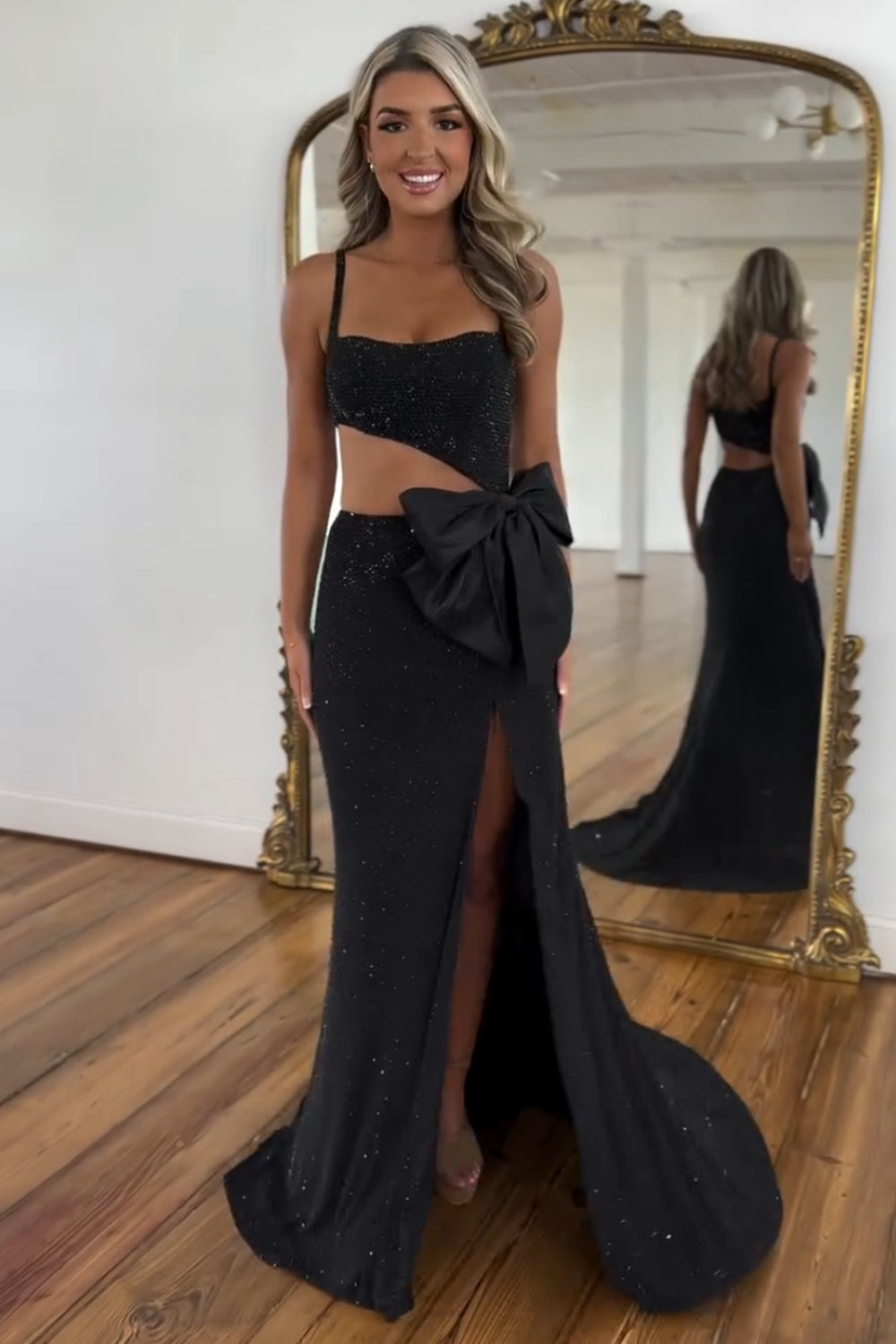 Robe de bal longue sirène à fines bretelles noires pailletées et découpes ornée de perles