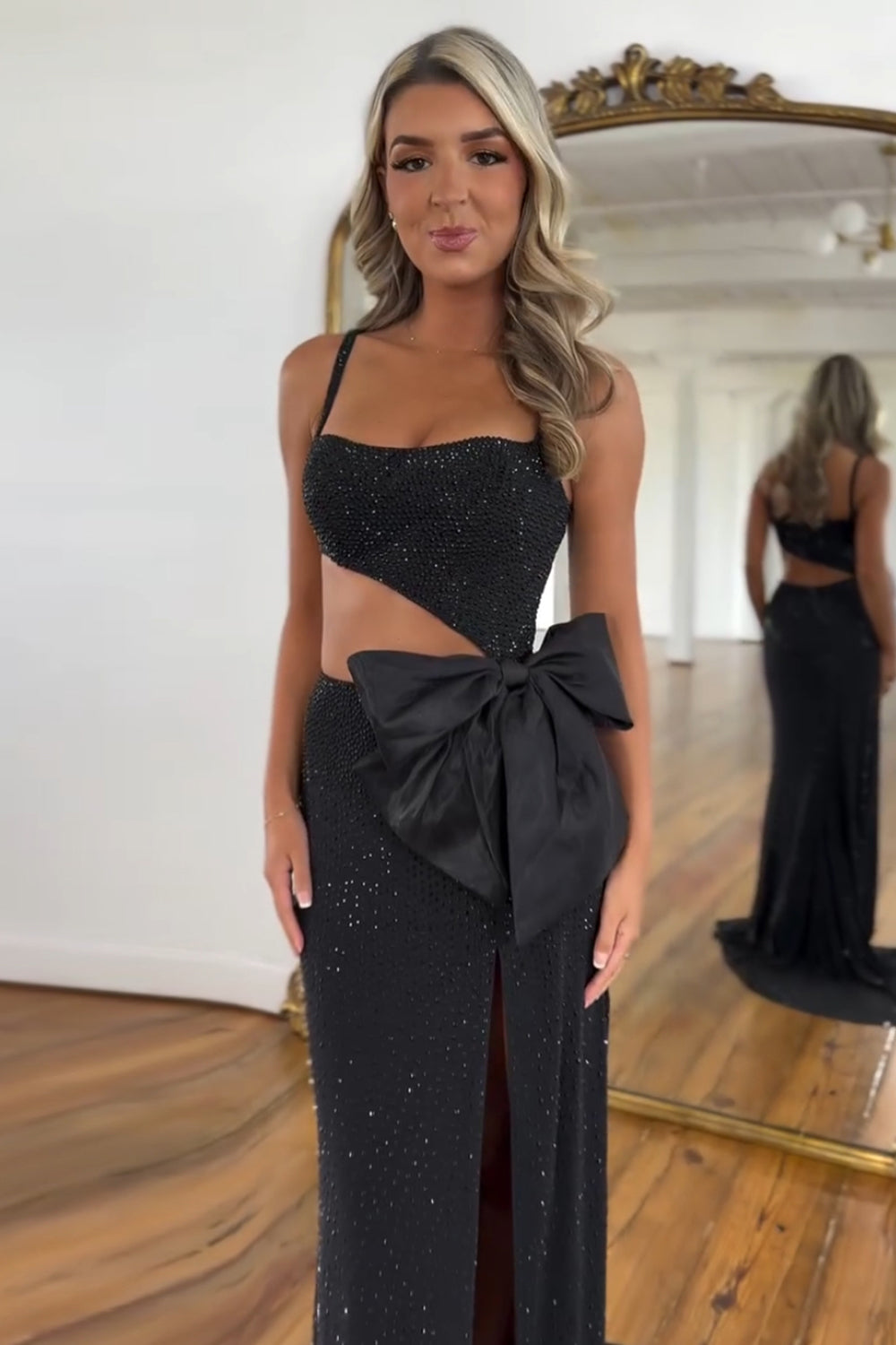Robe de bal longue sirène à fines bretelles noires pailletées et découpes ornée de perles
