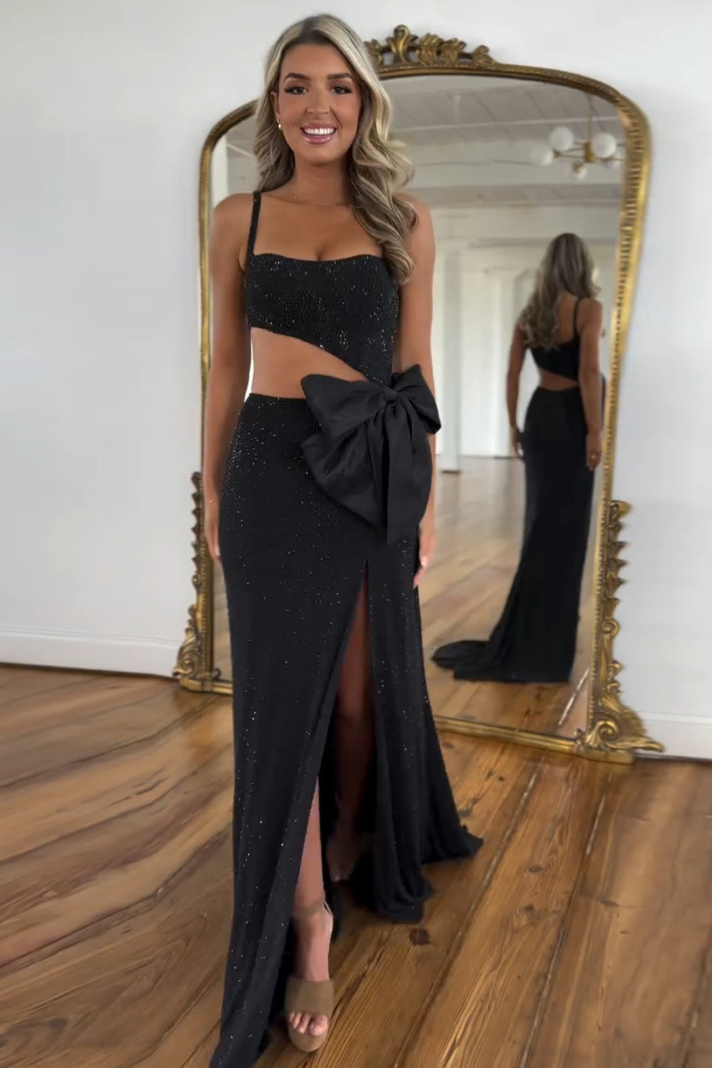 Robe de bal longue sirène à fines bretelles noires pailletées et découpes ornée de perles