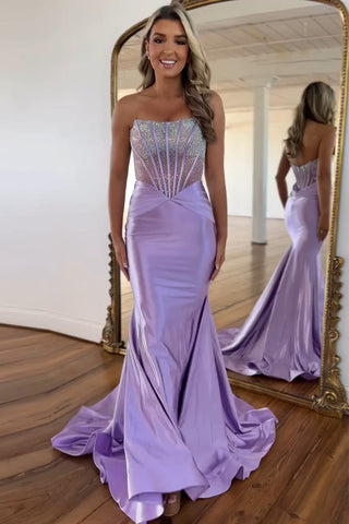 Vestido de fiesta largo de sirena morado sin tirantes, de satén con corsé y pedrería.