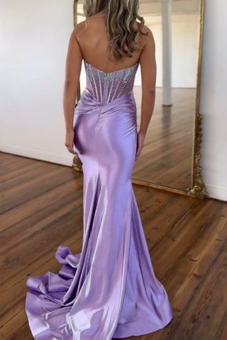 Vestido de fiesta largo de sirena morado sin tirantes, de satén con corsé y pedrería.