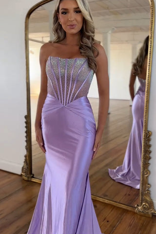 Vestido de fiesta largo de sirena morado sin tirantes, de satén con corsé y pedrería.