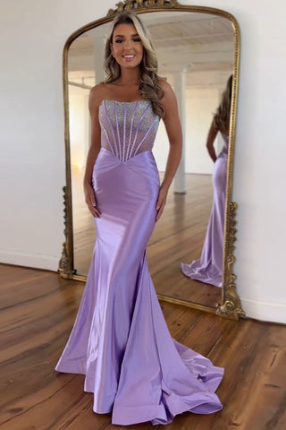 Vestido de fiesta largo de sirena morado sin tirantes, de satén con corsé y pedrería.