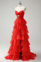 Robe de bal longue orange à volants et décolleté cœur, fendue.